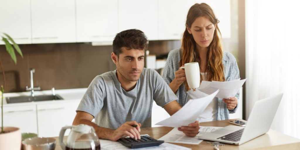 A young couple is studying their bills and expenses.